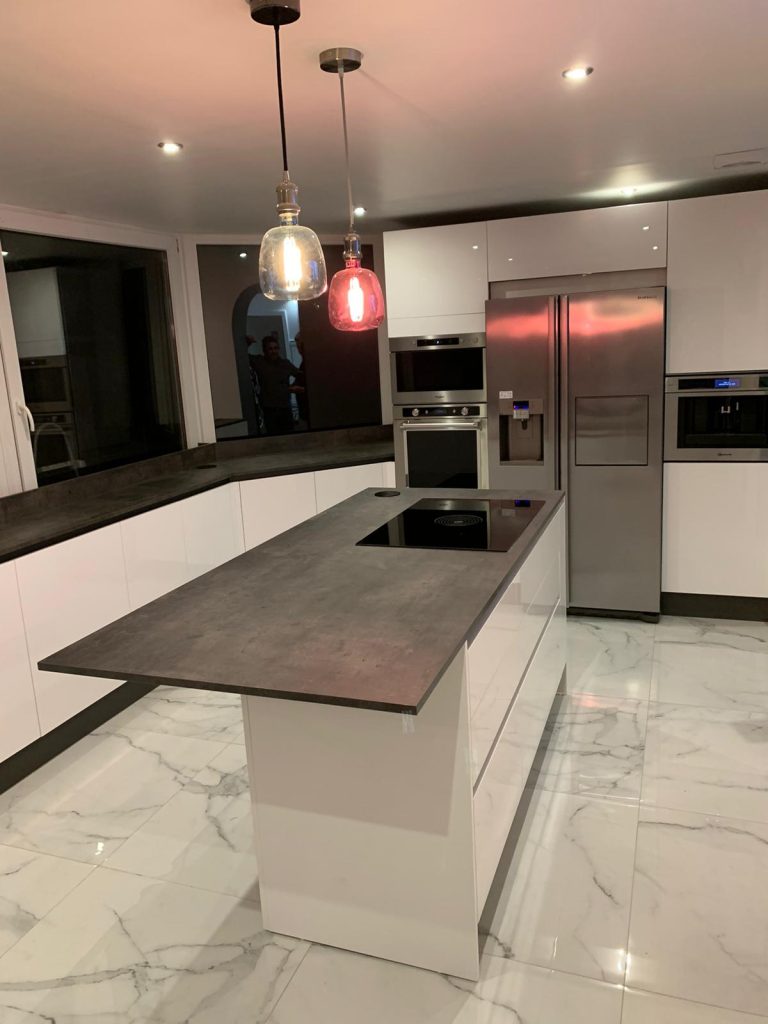L’art de cuisiner dans un écrin de lumière Dans cette cuisine aux lignes pures, chaque détail raconte une histoire de raffinement et de modernité. Les façades blanches brillantes issues de la gamme cloé de chez Arredo3 reflète la lumière comme un miroir d’élégance. L’îlot central, cœur vibrant de la pièce, invite aux instants partagés, aux recettes improvisées et aux confidences à la lueur des suspensions colorées. Les matériaux se répondent, les textures se complètent, et l’espace devient un lieu de vie aussi beau qu’intuitif. Une création signée BO DeZign, pensée pour sublimer le quotidien.